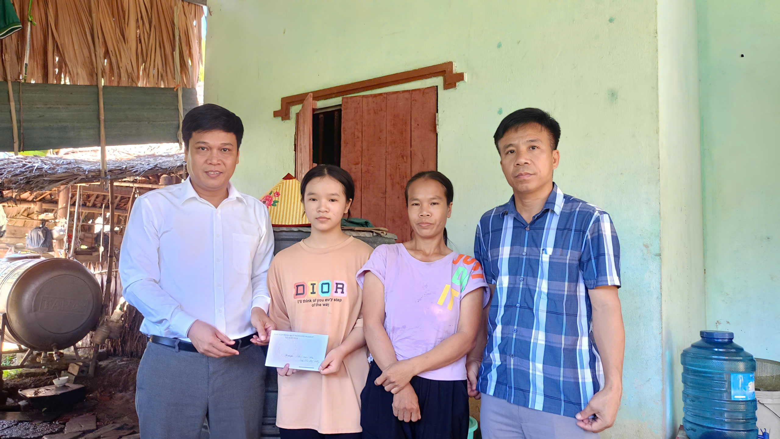 Bí thư Đảng ủy và Chủ tịch UBMTTQ xã tặng quà cho học sinh nghèo vượt khó